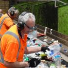 Workers manually separate the recycled items coming in on a conveyer belt. Photos: RNZ/Jimmy...