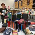 The Star Regent 24 Hour Book Sale volunteer Jill Bowie admires a table of beautiful folio books,...