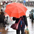 A Dunedin resident makes her way up Lower Stuart St in chilly, wet weather on Thursday. PHOTO:...