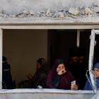 Palestinians look on at the site of an Israeli strike on a house in Rafah, in the southern Gaza...