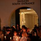 People hold candles during the a candlelight vigil in Sydney for the victims of the Bondi...