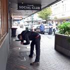 A Dunedin police photographer documents evidence at the scene of a serious assault in Princes St,...