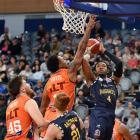 Otago Nuggets forward Kimani Lawrence puts up a shot despite the attention of Southland Sharks...