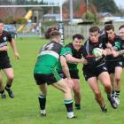 Edendale flanker Arden Knapp is surrounded by Riversdale Waikaka Vikings players as he makes a...