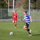 Wyndham Town player Freya Bols collects a pass, dribbles the ball about 15m and then boots it...