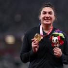 New Zealander Lisa Adams stands on the dais after winning the gold medal in the women’s shot put...