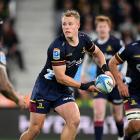 Highlanders second five, Sam Gilbert, tries to get something going against the Hurricanes on...