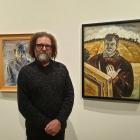 "Persona" curator Jim Geddes in the gallery of portraits. To his left is an Alan Pearson portrait...