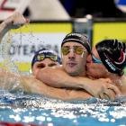 Kane Follows (centre) celebrates with Lewis Clareburt (left) and Sam Brown (right) after swimming...