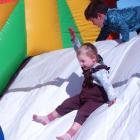 Rumer Wylie, 3, laughs her way down the slide on an inflatable obstacle course at the Weston Fun...