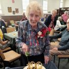 Eileen Fake cuts her 100th birthday party cake, a "House &amp; Garden" model made by Oamaru...