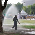 A girl runs through a water sprinkler on a hot summer day in New Delhi. PHOTO: REUTERS
