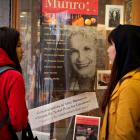 Customers look at a window display congratulating Canadian author Alice Munro at her own...