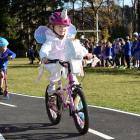 Abbotsford School pupil Ivy Robinson, 5, effortlessly cycles around a new track while fellow...