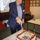 Former trustee and secretary John Levido, of Ranfurly, cuts the cake at the Maniototo Community...