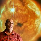University of Otago physics Prof Craig Rodger in front of an image of a coronal mass ejection ...
