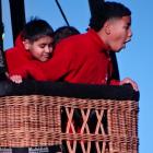 Manshil Mani (left), 10, and Haisini Manu, 10, are amazed at how high they are when a hot air...