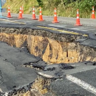 Damage to State Highway 23 with road cones around places where it was cracked and slumped in...