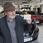Alistair Gilmour displays a road-user charge sticker, which will be required for all electric...