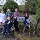Posing near their letterbox made from a McCormick sickle bar mower to make hay on their family...