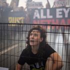 A woman sits in a cage as supporters and families of hostages, who were kidnapped during the...