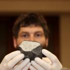 University of Otago geologist Dr Marshall Palmer shows the first meteorite believed to be found...