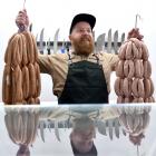 Greg Egerton, of Links Quality Meats, hoists two strings of the butchery’s award-winning sausages...
