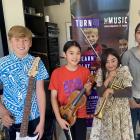 Turn Up The Music students from left, Mitch Smith, 12, on guitar, Rina Nakazawa, 12, on violin,...