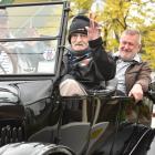 Jim Robertson (centre) takes a ride in a 1924 Ford Model T yesterday, with car owner David Roff ...