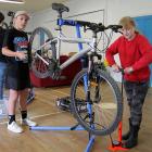 Volunteer bike mechanic Lukas Newbury, 13, helps Charlotte Brook, 10, recycle her new bike at...