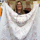 Tokomairiro High School principal Vicki Wish unpacks an antique quilt that has returned home...
