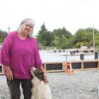 Excitement builds ... Raelene Burr pats her dog Ollie in front of the new house being built on...
