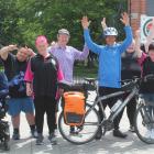 Jonathan Abplanalp stands behind his bike as he is welcomed by (from left) Jack Lovitt-Hurst,...