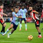 Gabriel Jesus of Arsenal runs with the ball under pressure from Bryan Mbeumo of Brentford in this...