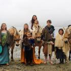 Young fans of the ancient Norwegian fjord horse breed pose in Viking garb with several horses at...