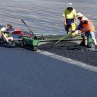 Poligras contractors spread a thin layer of rubber underlay in preparation for an Olympic Games...