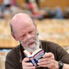 Regent Theatre 24-Hour Book Sale volunteer Brian Nicholls gets lost in the words while setting up...