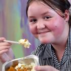Bathgate Park School pupil Kora Mason tucks into butter chicken at lunchtime yesterday. PHOTO:...