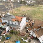 Debris lies around damaged houses the morning after a tornado touched down in Florissant,...