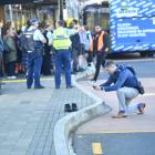 A security guard stands by as a police investigator takes photos of the scene where Enere Taana...
