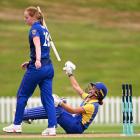 Otago spinner Eden Carson tosses her bat in the air in celebration after helping her side defeat...