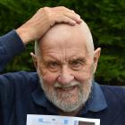 Dunedin man Dai Redshaw holds his bald head while displaying a photo of himself before his big...