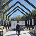 Rangiora-Ashley Community Board member Bruce McLaren kneels to take a photo of the wreaths laid...