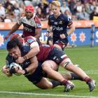The Highlanders’ Tanielu Tele’a scores a try while tackled by Harry Wilson of the Queensland Reds...