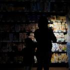 People use their phones and head torches to buy groceries inside the supermarket during the...