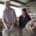 Harry Smith, of Ben Dhu Station, near Omarama, inspects a merino fleece, watched by his sister...