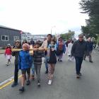 Children hold the weight of the cross on their shoulders leading about 100 people on a...