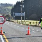 A traffic management worker redirects traffic from State Highway 1 up Donalds Hill Rd after the...