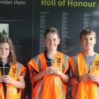 Inside Pukerau Cemetery’s kiosk and holding their flax crosses are (from left) Pippa, 10, and...