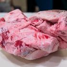 A large ball of frozen kidney during home rendering of beef tallow (left) and A container of...